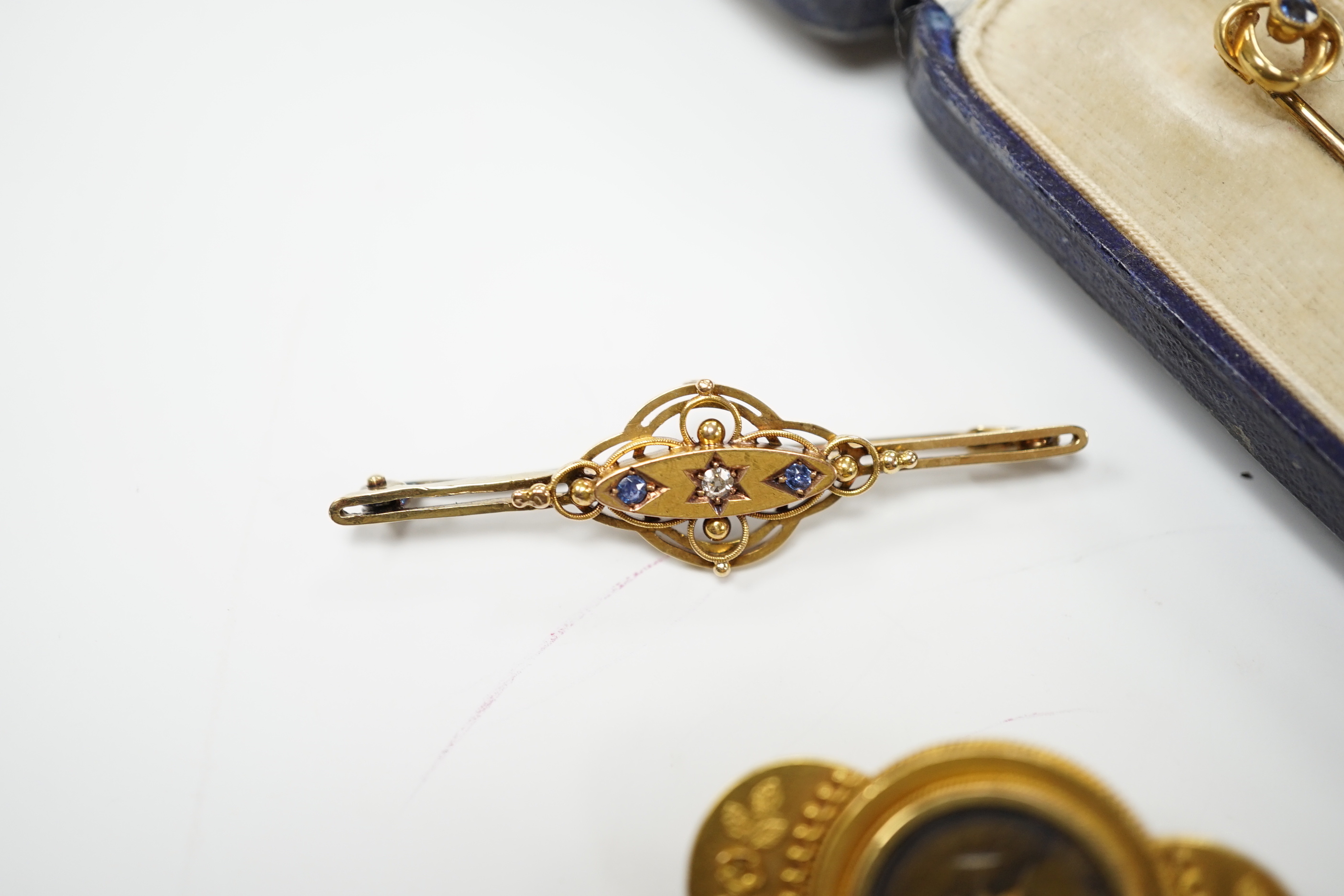 An Edwardian 15ct, sapphire and diamond set three stone bar brooch, 48mm, a later 14ct gold enamel and baroque pearls set 'Kingfisher' bar brooch, one other yellow metal and seed pearl set brooch and an Edwardian 15ct an